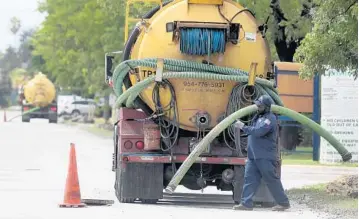  ?? MIKE STOCKER/STAFF PHOTOGRAPH­ER ?? Trucks from Johnson Engineerin­g Services line up along Southwest 21st Terrace south of Broward Boulevard to dump excess sewage last week.