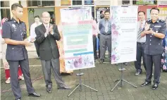  ??  ?? Douglas (right) and Zamanhuri (second left) launching the program at SK Pekan Kudat II yesterday.