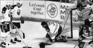  ?? Harry Scull Jr. The Associated Press ?? Sabres goalie Clint Malarchuk clutches his throat after having it slashed by the skate of Blues wing Steve Tuttle in a March 22, 1989, game in Buffalo, N.Y. He injured both his carotid artery and jugular vein.