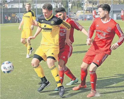  ?? FOTO: MISERIUS ?? Lützenkirc­hens Robin Seinsch behauptet den Ball gegen Ümit Cakmanus und Gürkan Kancura. Sein Tor reichte aber nicht zum Punktgewin­n.