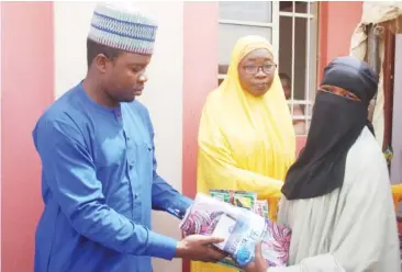  ??  ?? Councillor Nnguwar Abakwa ward, Malam Ismaila Galadima presenting items to one of the beneficiar­ies