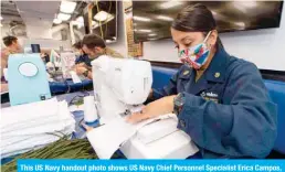  ??  ?? This US Navy handout photo shows US Navy Chief Personnel Specialist Erica Campos, from Houston, assigned to Arleigh Burke-class guided-missile destroyer USS Kidd (DDG 100) sewing fabric to make cloth face masks for the crew. — AFP