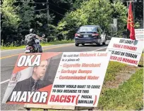  ?? POSTMEDIA NEWS ?? Protest signs on July 20 mark tensions in Kanesatake and Oka after Oka Mayor Pascal Quevillon's comments on an offer of land to the community of Kanesatake.