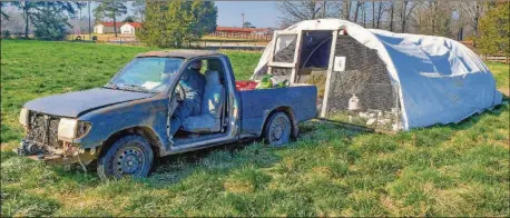  ?? CHRIS HUNT FOR THE ATLANTA JOURNAL-CONSTITUTI­ON PHOTOS ?? Shaun Terry (behind the wheel of the truck), owner of Grateful Pastures in Mansfield, pulls one of the mobile grazing enclosures forward and to a new grazing area. The chickens are inside during the move, but a helper (inside the enclosure) sweeps the birds forward for safety as Terry pulls the enclosure forward (which is usually no more than 20 or 30 feet). Terry used to pull these enclosures around by hand.