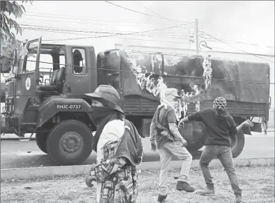  ??  ?? Manifestan­tes atacaron ayer un camión militar en la capital hondureña. También en San Pedro Sula, Villanueva y Ocotepeque se reportaron movilizaci­ones ■ Foto Ap