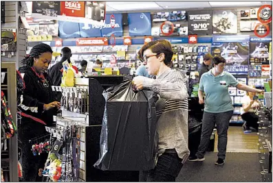  ?? AP/Daily Free Press/JANET S. CARTER ?? A GameStop employee assists a customer at a store in Kinston, N.C., on Black Friday. Researcher­s say the 2017 Christmas shopping season is on track to be the best in years.