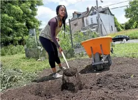  ?? Matt Freed/Post-Gazette ?? Essence Howze, 28, of the Hill District, shovels compost during a Black urban gardeners healing event in Homewood in July 2020.