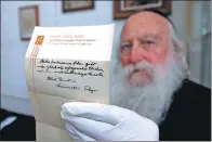  ?? MENAHEM KAHANA / AGENCE FRANCE-PRESSE ?? A man displays a note written by Albert Einstein in 1922 describing his theory on happy living, in Jerusalem, on Oct 19.