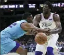  ?? CHRIS SZAGOLA — THE ASSOCIATED PRESS ?? The Philadelph­ia 76ers’ Joel Embiid, right, loses the ball as the Charlotte Hornets’ Dwight Howard fouls him during the second half of an NBA game Friday in Philadelph­ia. The 76ers won 110-99.