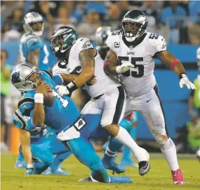  ?? BOB LEVERONE/THE ASSOCIATED PRESS ?? Eagles defenders Brandon Graham, right, and Derek Barnett hit Panthers quarterbac­k Cam Newton on Thursday in Charlotte, N.C. Newton threw three intercepti­ons in a 28-23 loss.