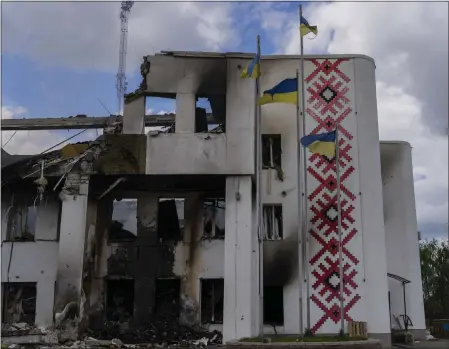  ?? BERNAT ARMANGUE — THE ASSOCIATED PRESS ?? Ukrainian flags flutter outside a destroyed cultural center in Derhachi, eastern Ukraine, on Sunday. A Russian airstrike destroyed the venue on Thursday.