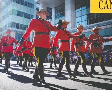  ?? JEFF MCINTOSH / THE CANADIAN PRESS ?? Members of the RCMP march in full red serge during the Calgary Stampede parade in July 2018.