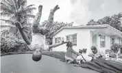  ?? AL DIAZ adiaz@miamiheral­d.com ?? Loyal, 6, jumps on a trampline while his grandmothe­r, Joan Pratt, talks with siblings Oliviea, Abigail and Terylin on her patio in Liberty City.