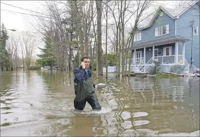  ?? CP PHOTO ?? A man makes his way through the flooded streets in Laval, Que., on May 10. Even as swollen rivers have receded in Quebec, some experts suggest historic flooding this year could mean critter and pest-related woes in months and years to come.