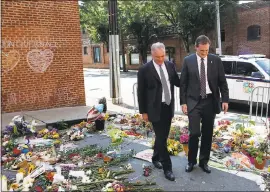  ?? JULIA RENDLEMAN — THE ASSOCIATED PRESS ?? Sen. Tim Kaine, left, and Charlottes­ville mayor Michael Signer visit a makeshift memorial Wednesday where Heather Heyer was killed when a car rammed into a crowd of people protesting a white nationalis­t rally Charlottes­ville, Virginia.