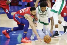  ??  ?? SWEPT: Philadelph­ia’s Ben Simmons and Marcus Smart reach for a loose ball.