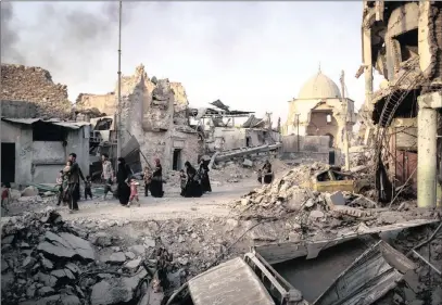  ?? PICTURE: AP ?? Displaced residents of Mosul make their way through the wrecked streets of the city.