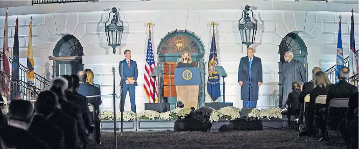  ??  ?? Amy Coney Barrett bei der Zeremonie im Weißen Haus. Flankiert wird sie von ihrem Mann Jesse (links), Präsident Trump (rechts) und Höchstrich­ter Clarence Thomas (ganz rechts).