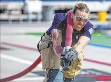  ??  ?? Las Vegas firefighte­r Jacqueline Palmer, a former world champion, participat­es in a run-through of the Firefighte­r Combat Challenge on Thursday.