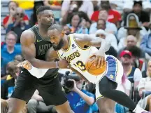  ?? AP-Yonhap ?? Los Angeles Lakers forward LeBron James, right, drives to the basket against New Orleans Pelicans forward Zion Williamson in the second half of an NBA basketball game in New Orleans, Sunday.