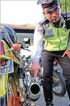  ?? CHUSNUL CAHYADI/JAWA POS ?? KNALPOT BRONG: Anggota Satlantas Polres Gresik menunjukka­n sepeda motor hasil Operasi Zebra Semeru 2017 yang berakhir 14 November.