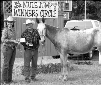  ?? TIMES photograph­s
by Laura Marts ?? Radar jumped 62 inches to win the pro jump at the 25th annual Pea Ridge Mule Jump. Owner Mike Call accepted the prize money from Jessica Funk.