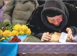  ?? Emilio Morenatti Associated Press ?? ROZA cries over the body of her husband, Oleksandr Maksymenko, 38, a civilian who was a volunteer in Ukraine’s armed forces and was killed in Bakhmut.