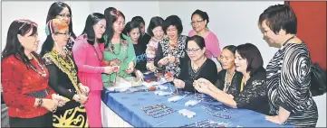  ??  ?? (Fourth left) Pearl and others learn how to make beads’ craft.