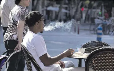  ?? Ferran Nadeu ?? Un joven fuma en una terraza del barrio de Sant Antoni de Barcelona.