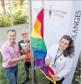  ?? PETER McCABE ?? MP Peter Schiefke, left, Pincourt Mayor Yvan Cardinal and Julie Lemieux, the first known transgende­r elected mayor in Canada, raise the gay Pride flag at Schiefke’s office in Vaudreuil-Dorion on Sunday.