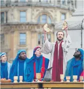  ?? ?? GOOD FRIDAY EVENTS: Main, the cast of the Heptonstal­l Pace Egg; right, The Passion of Jesus is performed in Trafalgar Square; left, pilgrims carry crosses across the sands at low tide to the Holy Island of Lindisfarn­e .