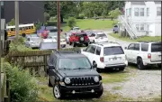  ?? NWA Democrat-Gazette/DAVID GOTTSCHALK ?? Cars are visible parked in marked parking spaces Tuesday in a gravel parking lot on the east side of Buchanan Avenue on the opposite side of Fayettevil­le High School.