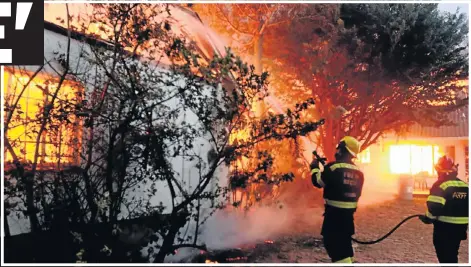  ??  ?? AWESOME FORCE: Firefighte­rs battle in vain to stop the inferno engulfing the Woodridge school premises