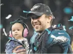 ?? Rob Carr / Getty Images ?? Philadelph­ia quarterbac­k Nick Foles, shown with his daughter, Lily, earned the MVP award after throwing for 373 yards in a victory.