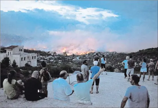  ?? ANGELOS TZORTZINIS / AFP ?? El fuego avanzaba la noche del lunes en Rafina, consumiend­o pinos, casas, vehículos y vidas humanas