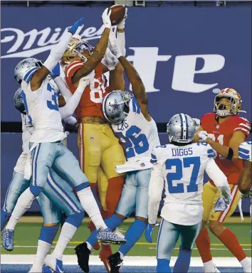  ?? MICHAEL AINSWORTH — THE ASSOCIATED PRESS ?? 49ers wide receiver Kendrick Bourne leaps above Dallas Cowboys’ Donovan Wilson, left, and Jourdan Lewis (26) to catch a Hail Mary pass in the end zone for a touchdown in the second half in Arlington, Texas on Sunday.