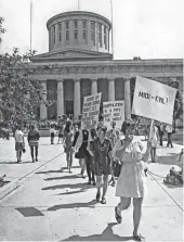  ?? DISPATCH FILE PHOTO ?? In 1970, attendees at a Women’s Liberation meeting picket to protest midi-length fashions. They were on their way to the Lazarus department store. A peace group, which identified itself as Quakers, took advantage of the situation and members read a list of Vietnam War dead.