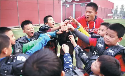  ?? PHOTOS BY ZOU HONG / CHINA DAILY ?? A coach mobilizes boys before a football match at the “Man-up training club” in Beijing.