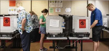  ?? REANN HUBER PHOTOS / REANN.HUBER@AJC.COM ?? People cast their votes during early voting at the Dunwoody Public Library on Saturday.