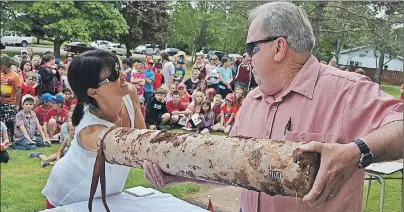  ?? ERIC MCCARTHY/JOURNAL PIONEER ?? O’Leary Elementary School principal Susan Trail reaches into a time capsule to retrieve the contents as retired principal John Rogers holds the cylinder steady.