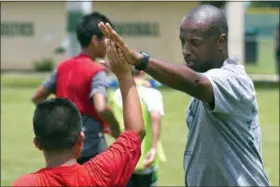  ?? DOUG ENGLE — STAR-BANNER VIA AP ?? In a September 2016 photo, Yale’s women’s Head Soccer Coach Rudy Meredith gives a high five to a player after making a great play in a scrimmage, in Frankfort, Ky. According to the federal indictment­s unsealed Tuesday Meredith put a prospectiv­e student who didn’t play soccer on a school list of recruits, doctored her supporting portfolio to indicate she was a player, and later accepted $400,000 from the head of a college placement company.