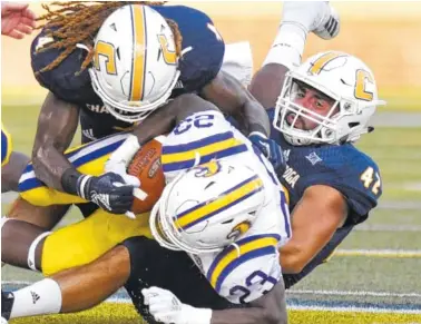  ?? STAFF PHOTO BY ROBIN RUDD ?? UTC’S Tavon Lawson, top, and Hawk Schrider tackle Tennessee Tech’s Andrew Goldsmith during the Mocs’ season opener on Aug. 30. The undefeated Mocs play Samford tonight at Finley Stadium. The Bulldogs are ranked No. 17 in the FCS.