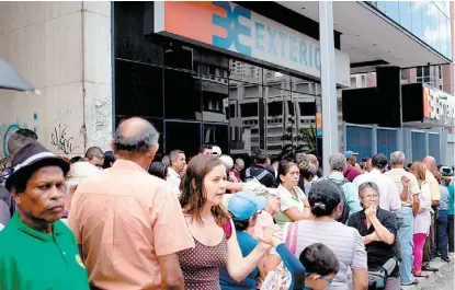  ?? REUTERS ?? La gente hace fila para retirar efectivo de un cajero automático en la capital.