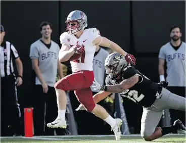  ?? — GETTY IMAGES ?? Washington State’s Max Borghi fends off Colorado’s Rick Gamboa en route to a secondquar­ter TD, helping the Cougars to a 31-7 rout of the Buffaloes.
