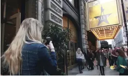  ??  ?? Alex Richards takes a photo of Meera Ganesh outside the CIBC Theatre after watching “Hamilton: An American Musical” in Chicago.