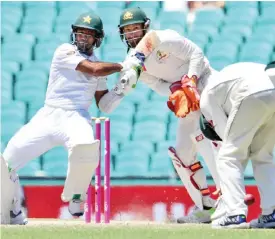 ??  ?? SYDNEY: Pakistan batsman Asad Shafiq (L) pulls the ball to square as Australia’s Matthew Wade (C) and Peter Handscomb (R) look on on the final day of the third cricket Test match at the SCG, in Sydney. —AFP