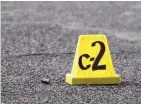  ?? ROBERTO E. ROSALES/JOURNAL ?? An evidence marker is placed next to a bullet at the scene of a fatal shooting at Rhode Island and Chico NE on Monday.