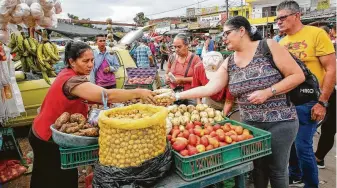  ?? Schneyder Mendoza / AFP / Getty Images ?? People sell groceries to desperate Venezuelan­s in Cucuta, Colombia. Venezuelan President Nicolas Maduro vowed on Friday not to let in “fake”aid from the United States.