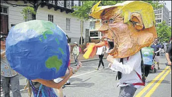  ?? REUTERS ?? Protesters dressed as the earth and Donald Trump have a mock fight in Washington.