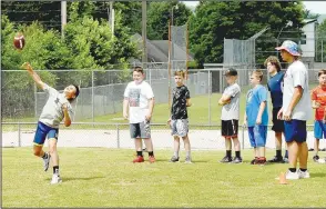  ??  ?? Prairie Grove fifth-grader Cash Oxford throws the football during the punt, pass and kick portion of Prairie Grove’s annual pee wee football camp held last week at Tiger Den Stadium.